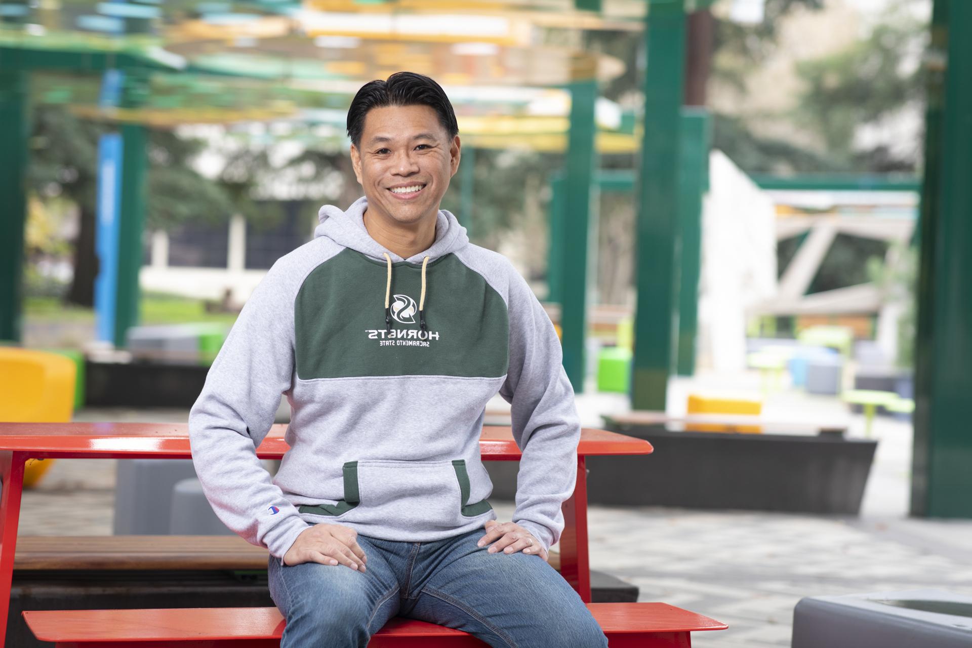 Alumnus Baldwin Chiu sports his Sac State gear and a huge smile on campus.