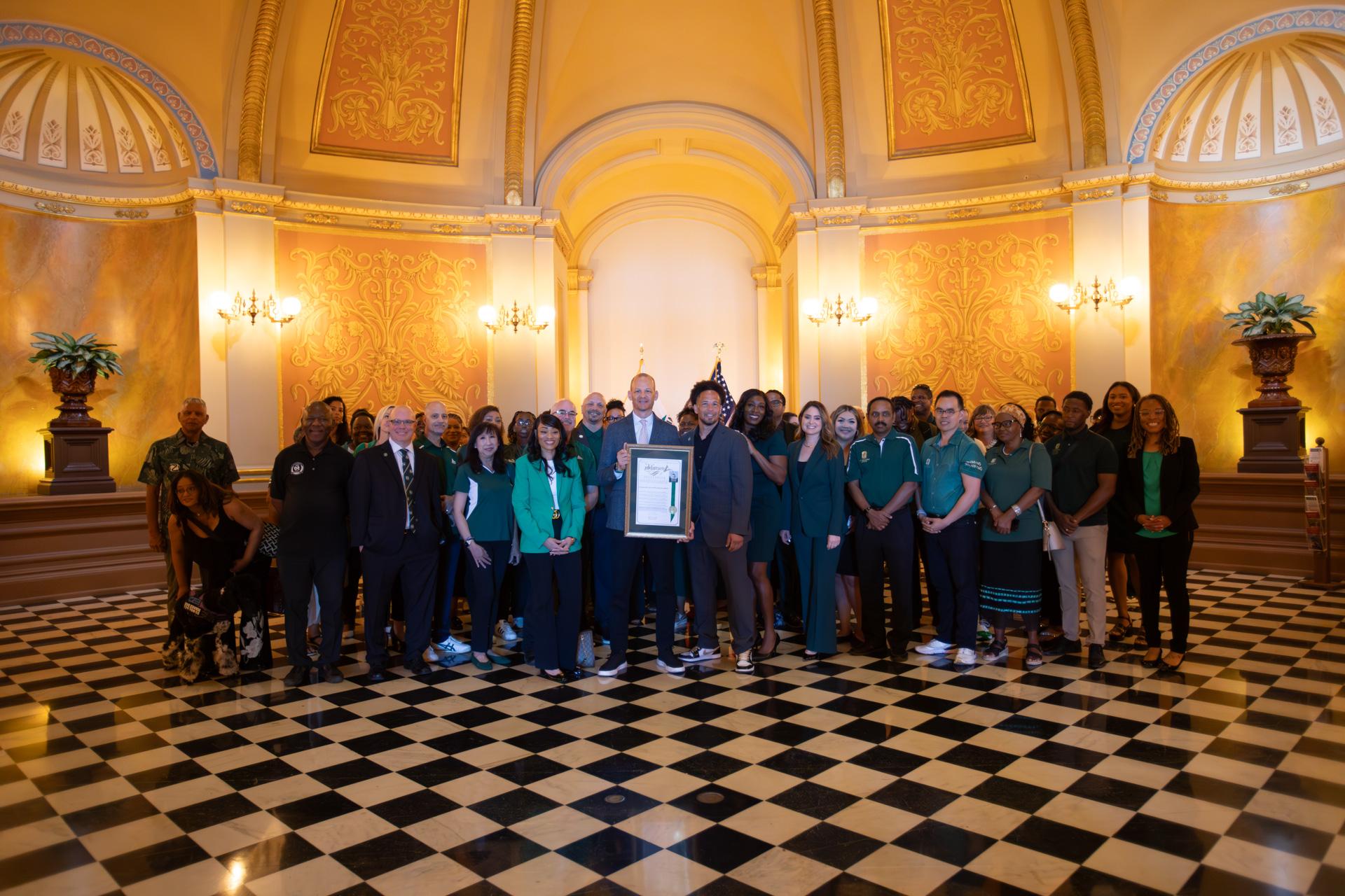 State lawmakers and members of the Sacramento State administration pose inside the Capitol.